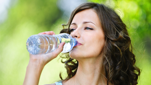 ragazza beve acqua dalla bottiglia